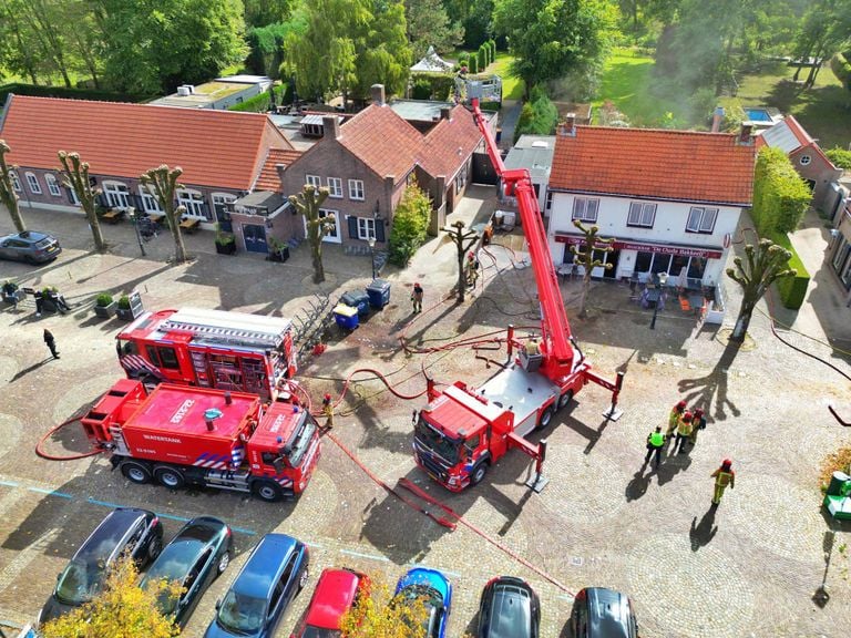 Een hoogwerker was nodig om het vuur onder controle te krijgen (foto: persbureau Heitink)