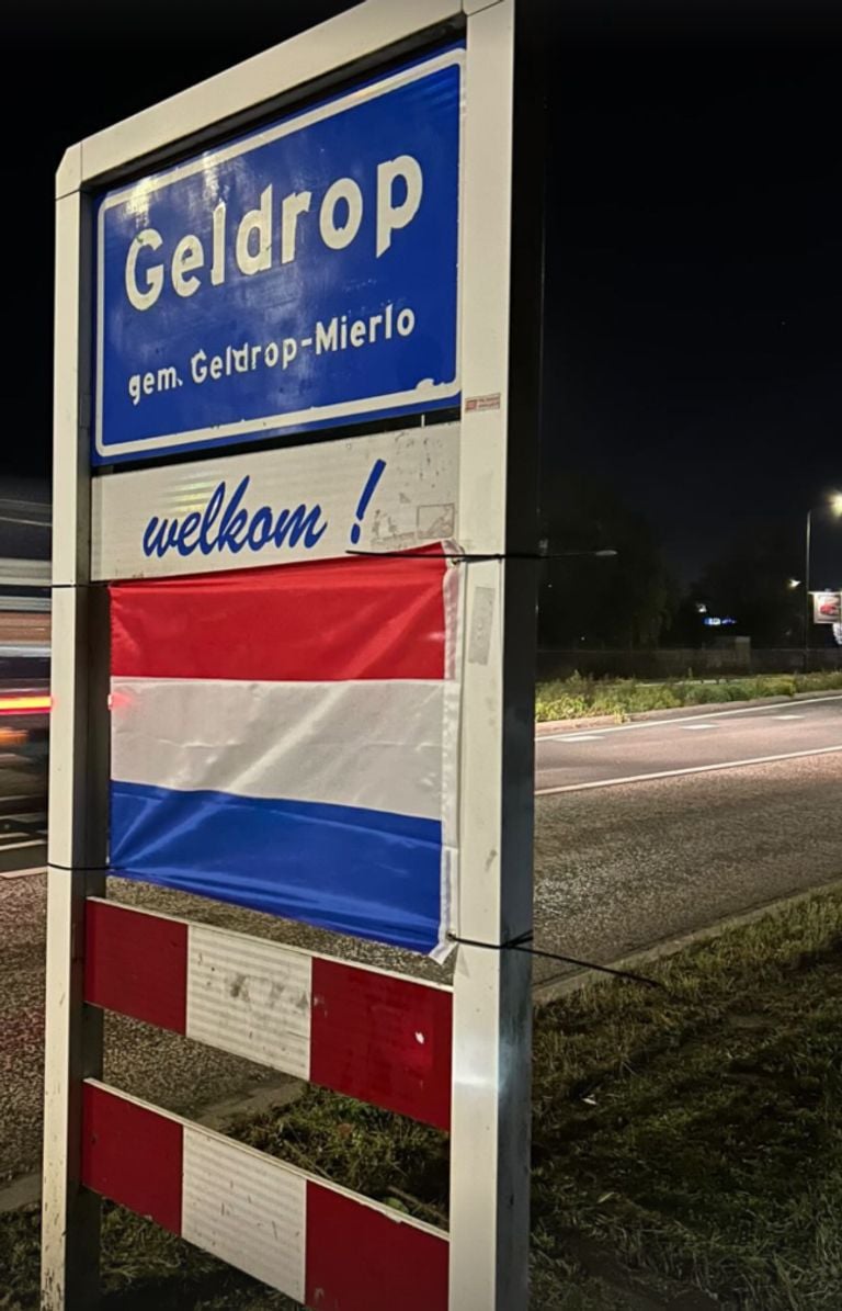 In Geldrop is de vlag gespannen tussen een welkomstbord (foto: Operatie Hijs de Vlag NL Instagram).