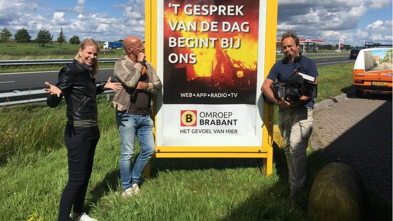 Medewerkers van RTV Noord verbazen zich over het reclamebord. (Foto: Facebook Expeditie Grunnen)