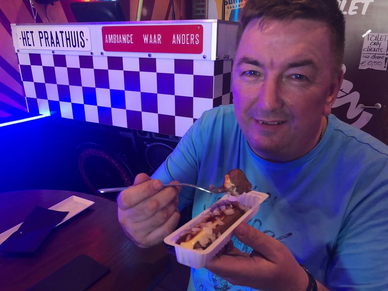 Uitbater Frans Damen eet een frikandel in zijn Hollandse café in Spanje.