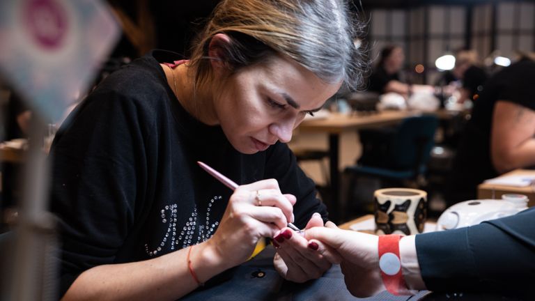 De nagelstyliste geconcentreerd aan het werk (foto: Kevin Cordewener)