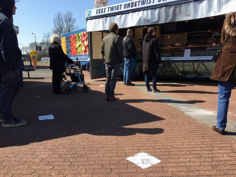 Op je eigen witte stip in de rij voor de visboer (foto: Omroep Brabant).