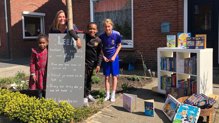 Marly, juf Lidy, Ibrahim en Roos bij de boekenkast (foto: Erik Peeters)