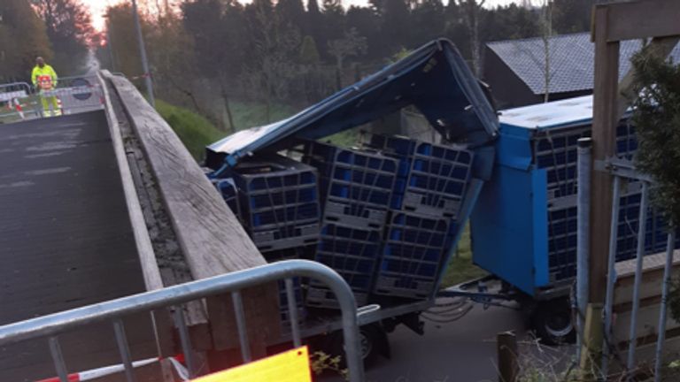 De vrachtwagen zit vast onder de fietsbrug. 