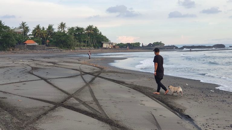 Donee en hond Zoë op het verlaten strand van Bali. 