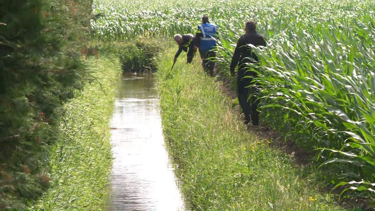 Agenten doorzoeken de sloot naast het huis (foto: Omroep Brabant).