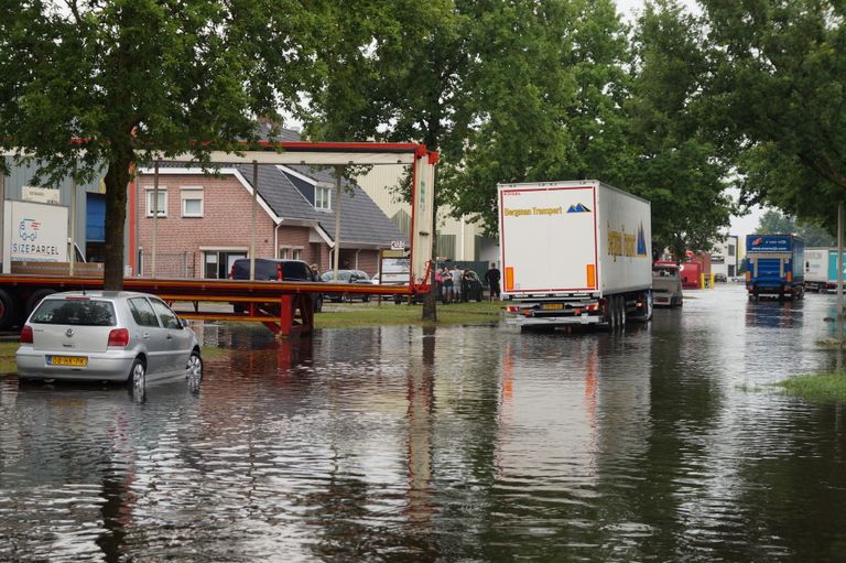 Ook vrachtwagens moeten zich een weg door het water banen (Foto: Erik Haverhals).