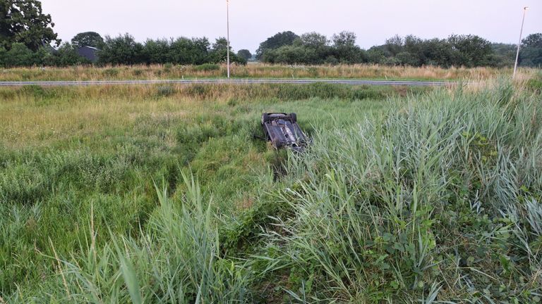 Het voertuig eindigde op z'n kop in een weiland naast de weg (foto: SQ Vision).