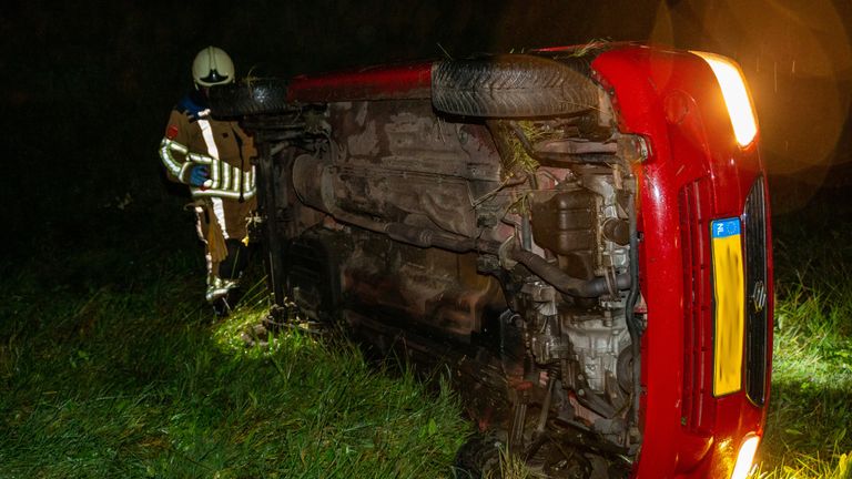 De auto raakte na de botsing op de A59 bij Den Hout van de weg en eindigde op zijn kant (foto: Mathijs Bertens/SQ Vision).