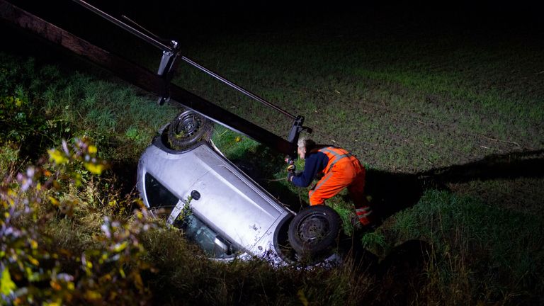 De auto die van het talud bij Someren schoot, is getakeld (foto: Walter van Bussel/SQ Vision).