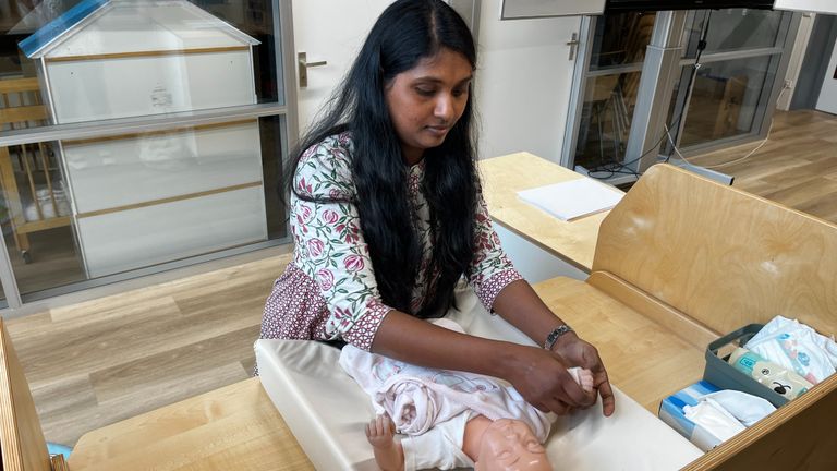 Divya Madhuri Reddy oefent bij het verschonen van een pop (foto: Rogier van Son).