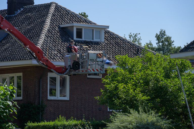 De man werd van het dak van het huis in Breda gehaald (foto: Tom van der Put/SQ Vision).