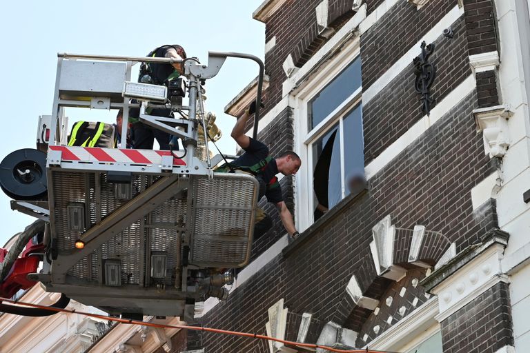 Via een hoogwerker lukte het de hulpdiensten de vrouw te bevrijden uit haar huis aan de Haven in Breda (foto: Perry Roovers/SQ Vision).