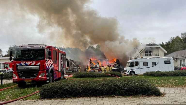 De woonwagens links en rechts van worden natgehouden (foto: Imke van de Laar).