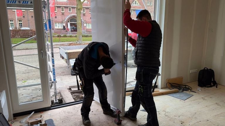 Bouwvakkers aan het werk in het huis, op de achtergrond de overburen: De Rooi Pannen (foto: Tom van den Oetelaar).