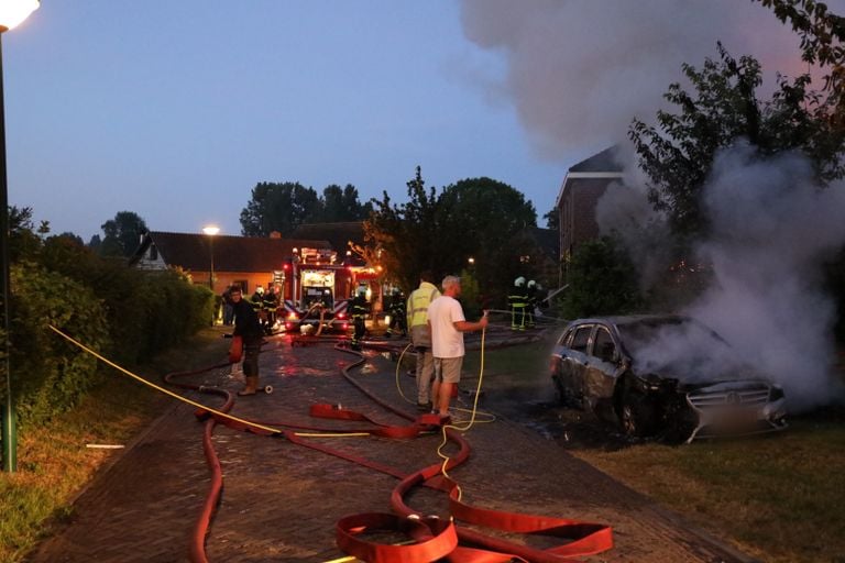 Mensen proberen bij de woning- en autobrand in Genderen te redden wat er te redden valt (foto: FPMB/Erik Haverhals).