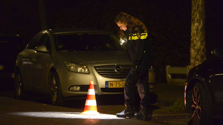 Een agente doet onderzoek na de melding van een schietpartij aan de Abeelstraat in Breda (foto: Perry Roovers/SQ Vision).