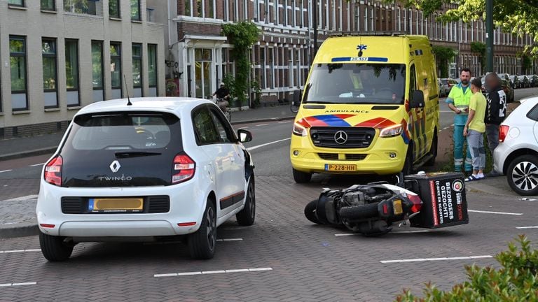 De scooterrijder werd na de aanrijding in Breda nagekeken door ambulancepersoneel (foto: Perry Roovers/SQ Vision).