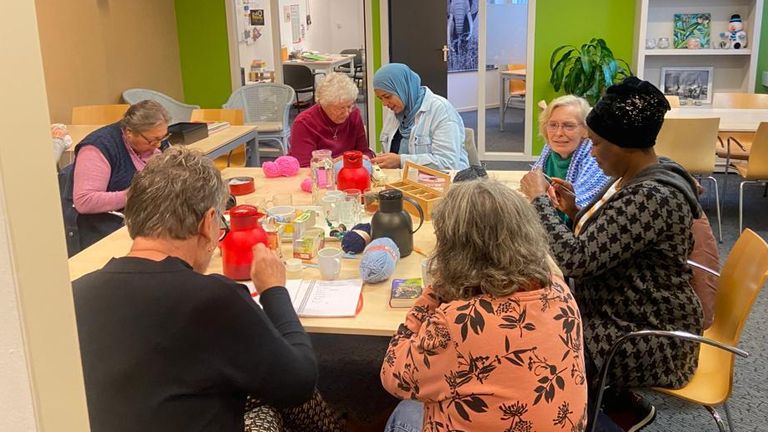 Bewoners en vrijwilligers tijdens een van de naailessen (foto: Leyla Kalender). 