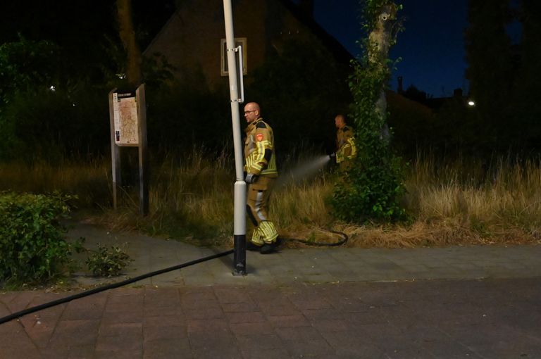 De brandweer bluste nog even na nadat een agent het vuur aan de Rochussenstraat in Breda al had gedoofd (foto: Perry Roovers/SQ Vision).