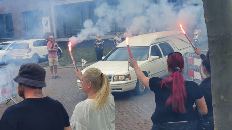 Mensen wachtten de rouwwagen op met fakkels.