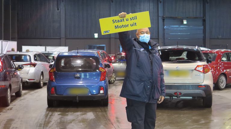 Beveiliger Juny maakt wijst automobilisten erop hun motor uit te zetten (foto: Joris van Duin).