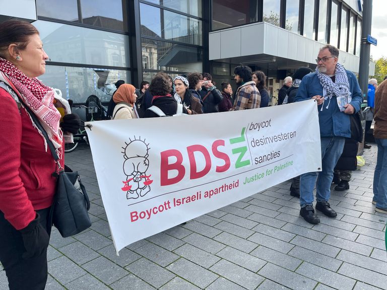 Demonstranten lopen met spandoeken. (Foto: Jan Waalen)