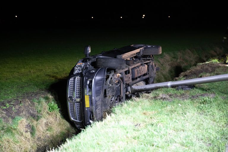 De automobilist reed een lantaarnpaal uit de grond voordat hij in de sloot in Rucphen terechtkwam (foto: Christian Traets/SQ Vision). 