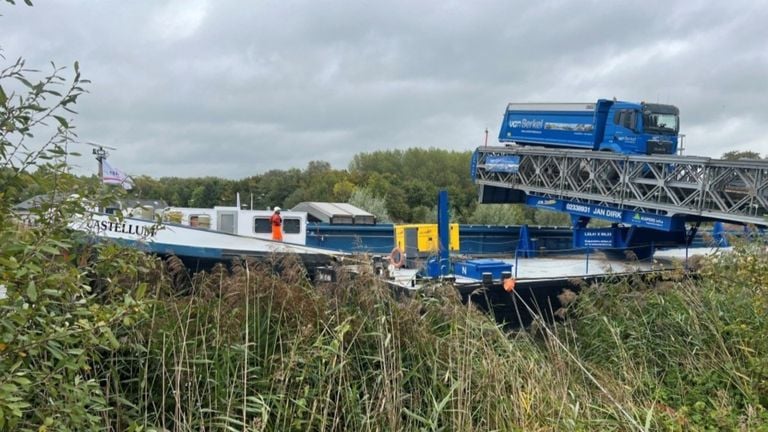 Vrachtwagens vol met zand rijden op een speciaal aangelegde brug om het zand in de boot te krijgen (foto: Waterschap Aa en Maas).