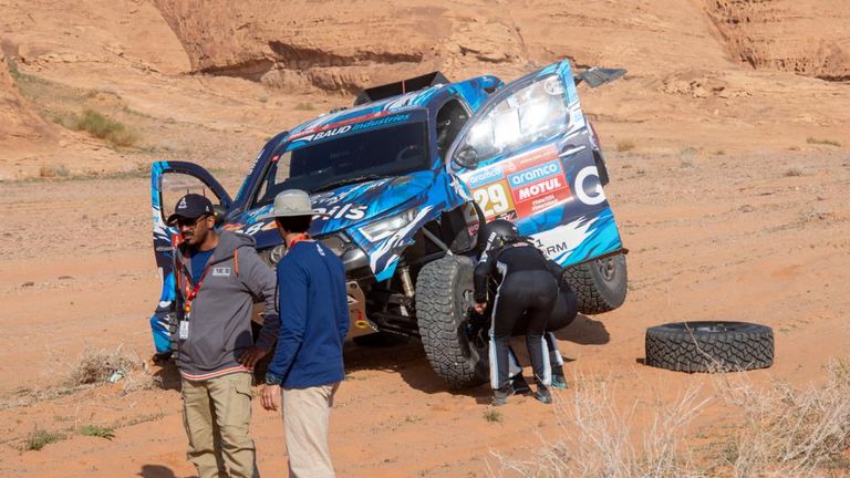 De coureurs kijken naar de schade aan de auto (foto: Gerard Laurenssen/Dakar Press). 