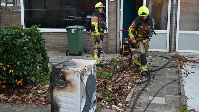 De in brand gevlogen wasdroger staat klaar om afgevoerd te worden (foto: Toby de Kort/SQ Vision).