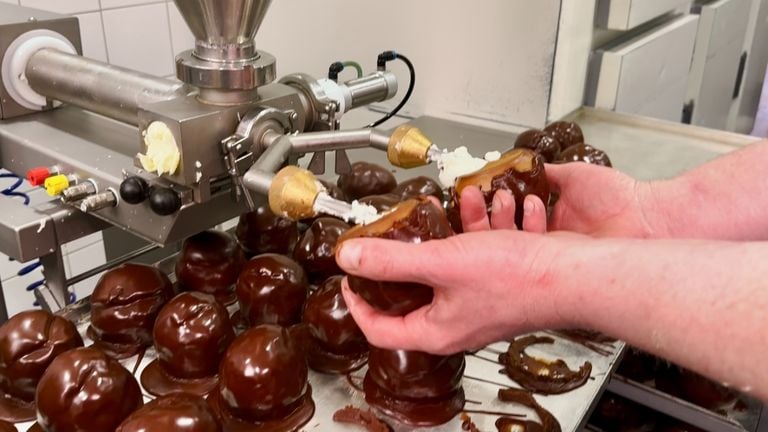 De Bosschebollen worden per twee gevuld met slagroom (foto: Jan Peels)