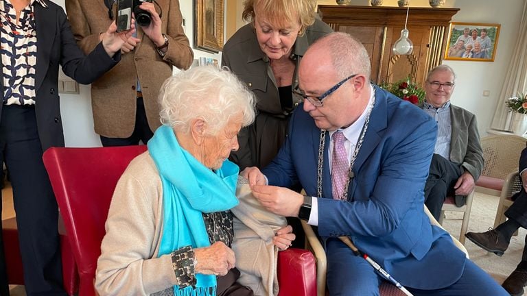 Burgemeester Oosterveer van Waalre speldt het speldje op (foto: Rogier van Son).