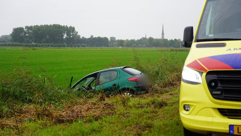 Een van de betrokken auto's eindigde in de sloot naast de Brandestraat in Hooge Zwaluwe (foto: Jeroen Stuve/SQ Vision).