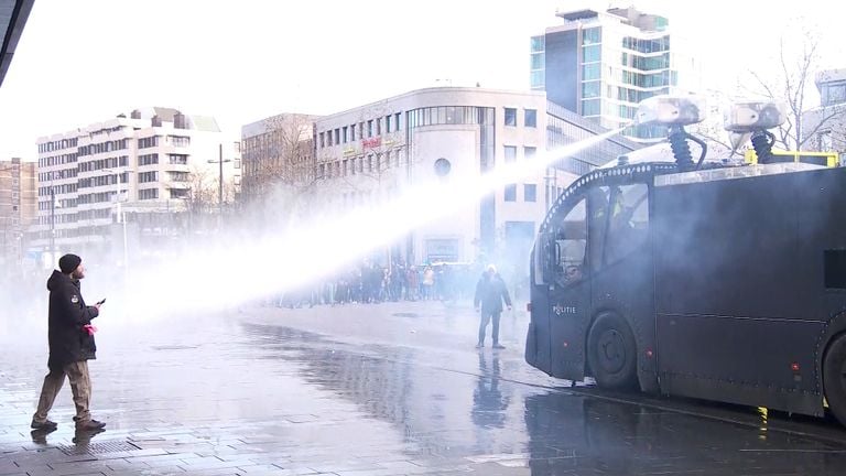 Politie zet een waterkanon in.