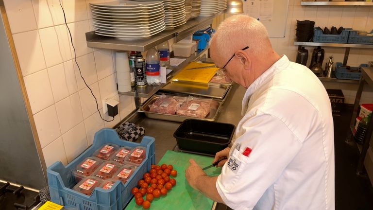 John Michielsen snijdt de tomaten voor de lunch.