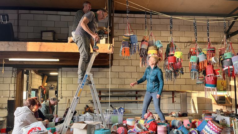 Bewoners van Almkerk werken samen aan hun lichtinstallatie, bestaande uit kleurrijk versierde conservenblikken (foto: Kunstlicht Almkerk)