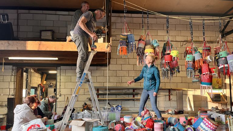 Bewoners van Almkerk werken samen aan hun lichtinstallatie, bestaande uit kleurrijk versierde conservenblikken (foto: Kunstlicht Almkerk)