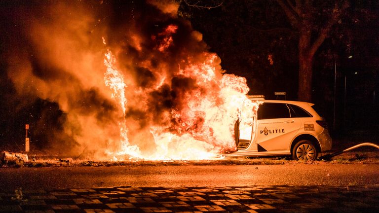 De politieauto vatte na de crash in de Tilburgse Sweelincklaan vlam (foto: Jack Brekelmans/SQ Vision).