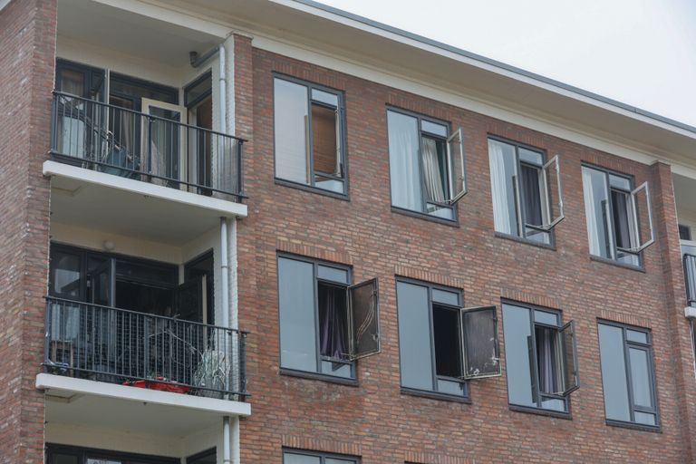 De flat werd vrijdagochtend nog altijd geventileerd om de rook uit het gebouw te krijgen (foto: Arno van der Linden/SQ Vision).