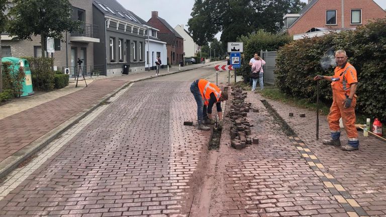 Stratenmakers zijn in de weer met de zichtbare grenslijn in de weg (foto: Erik Peeters).