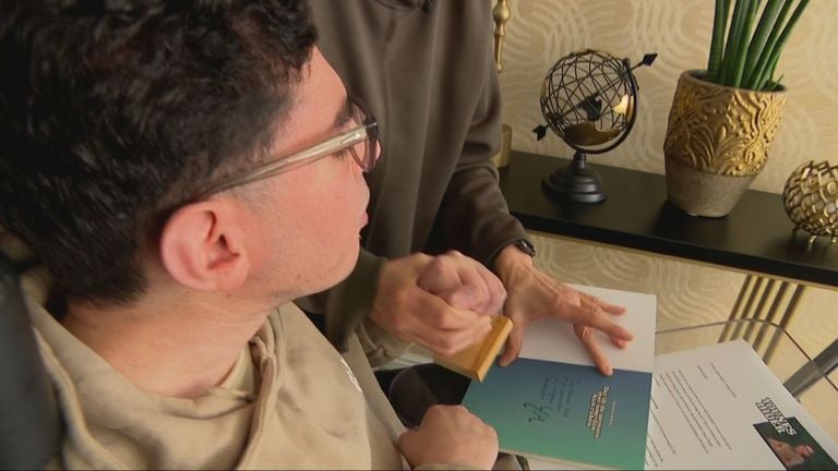 Younes signeert met een stempel en hulp van zijn moeder zijn boek (foto: Jan Peels)