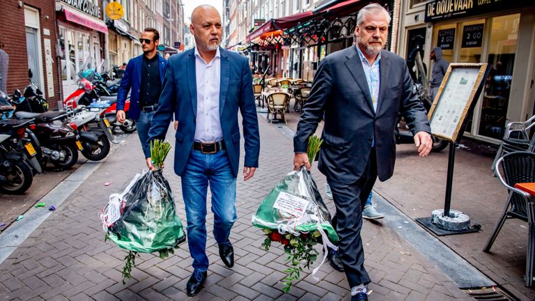 Advocaten Peter Schouten en Onno de Jong leggen bloemen neer (foto: ANP).