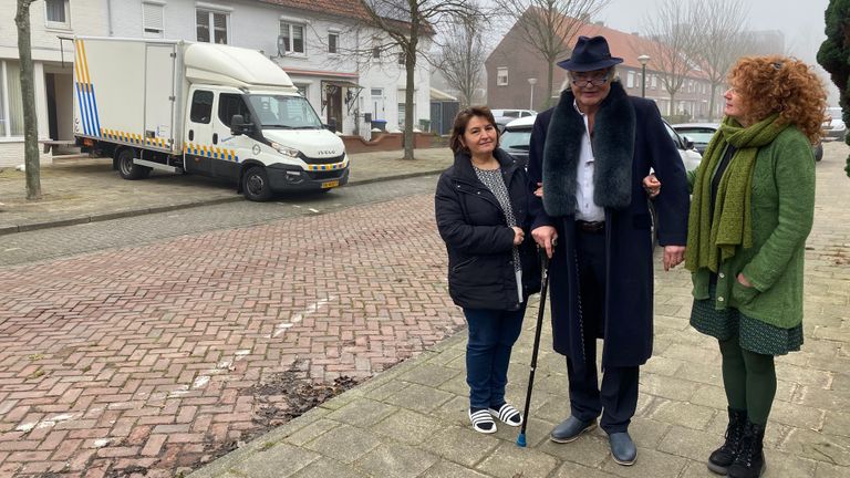 De buurvrouwen kijken verdrietig toe naar de eerste meubels die worden opgehaald.