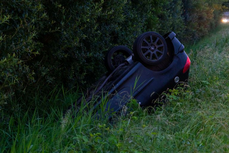 De auto belandde ondersteboven in de berm naast de A50 bij Schaijk (foto: Gabor Heeres/SQVision). 