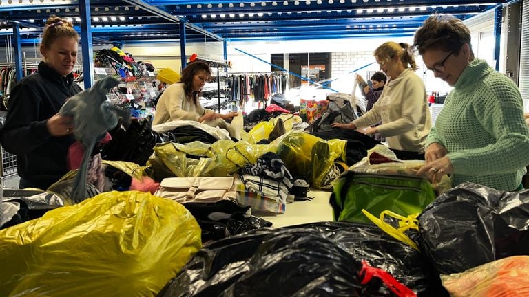 Tientallen vrijwilligers helpen om de kleding te sorteren (foto: Rogier van Son).