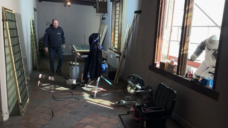 Een timmerman en schilder zijn druk in de weer op Kasteel Dussen (foto: Niek de Bruijn).